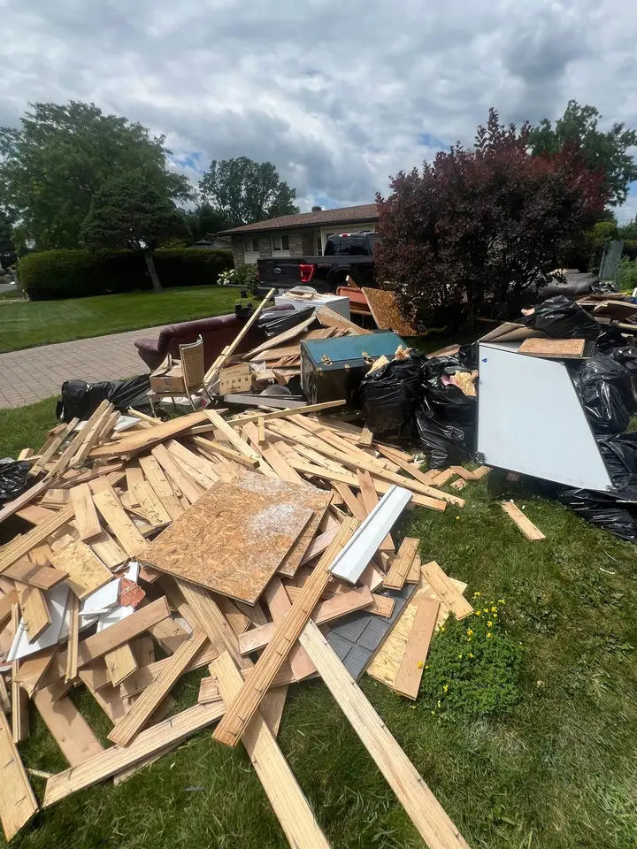 Wood flooring, boards and bags of renovation debris piled on a front lawn